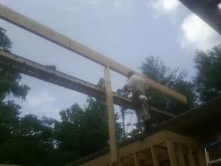 Carpenter setting a ridge beam over a new addition frame — Ice Dam Removal by Roofing Brothers in Tiffin